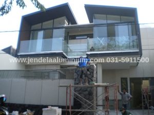 Pasang aluminium YKK hitam dan kaca tempered pada rumah modern di Manyar Surabaya