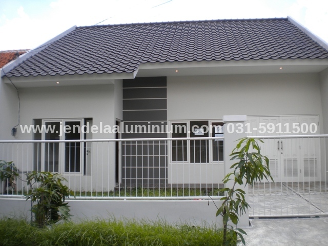 Jendela aluminium warna putih pada rumah minimalis modern di Surabaya dengan desain elegan, kaca bening, dan pemasangan rapi oleh kontraktor aluminium profesional.