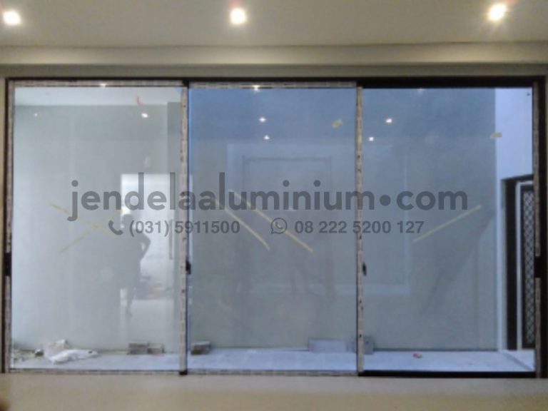 Jasa pasang pintu sliding aluminium 3 daun warna hitam dengan kaca bening untuk rumah modern oleh CV Karunia Mandiri Surabaya.