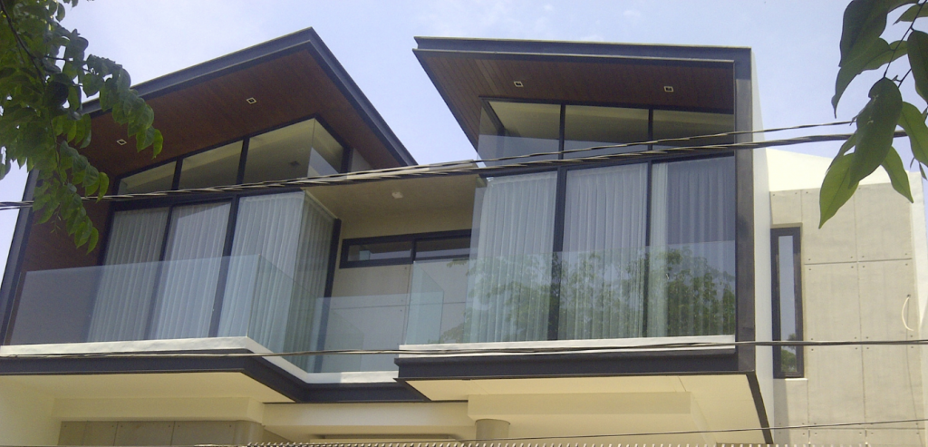Kusen aluminium 4" YKK dan railing kaca tempered rumah modern di Surabaya