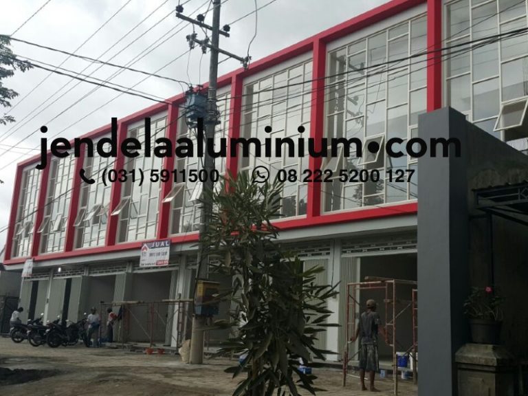 Partisi aluminium dengan jendela jungkit warna putih tulang untuk ruko di Jember menggunakan kaca bening dengan desain modern dan pemasangan rapi.