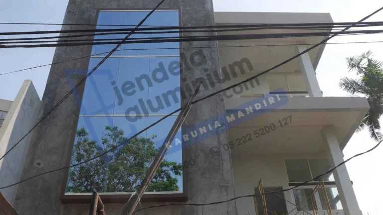 Fasad kantor di Darmo Surabaya Barat menggunakan kaca Stopsol dan kusen aluminium Alexindo 4 inci dengan desain modern minimalis.